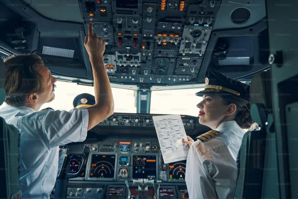 Pilots preparing for ICAO English exam with checklist in cockpit